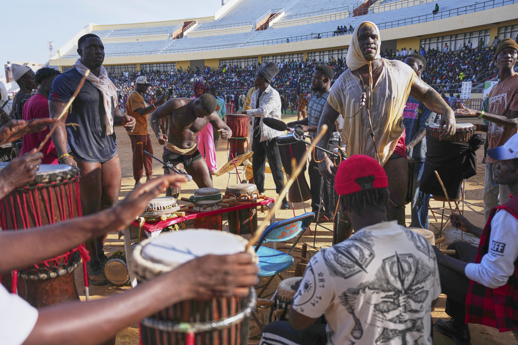 Wrestlers perform a traditional dance at a wrestling competition at the national arena in Dakar, Senegal, Sunday, March 29, 2026. (AP Photo/Misper Apawu)