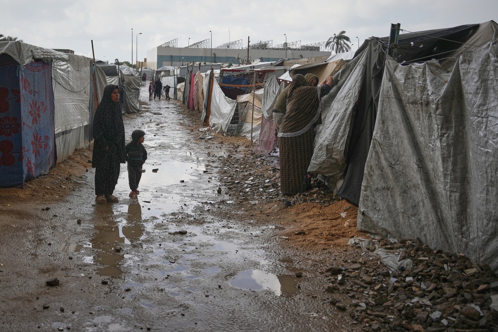 Hussein and Khawla Abu Arabiya adjust their tent to protect the interior from a rainstorm at a temporary camp in Deir al-Balah, in the central Gaza Strip, on Friday, Nov. 14, 2025. (AP Photo/Abdel Kareem Hana)