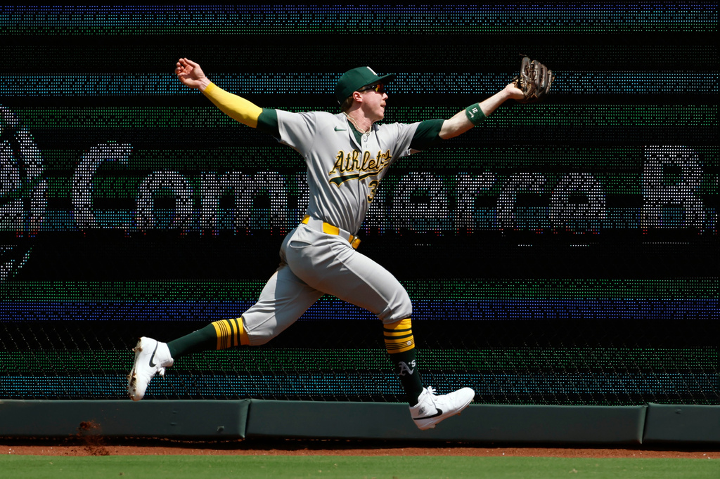 Athletics left fielder Zack Gelof reaches to catch a fly ball hit by Kansas City Royals' Nick Loftin during the first inning of a baseball game in Kansas City, Mo., Thursday, Aug. 20, 2026. (AP Photo/Colin E. Braley)