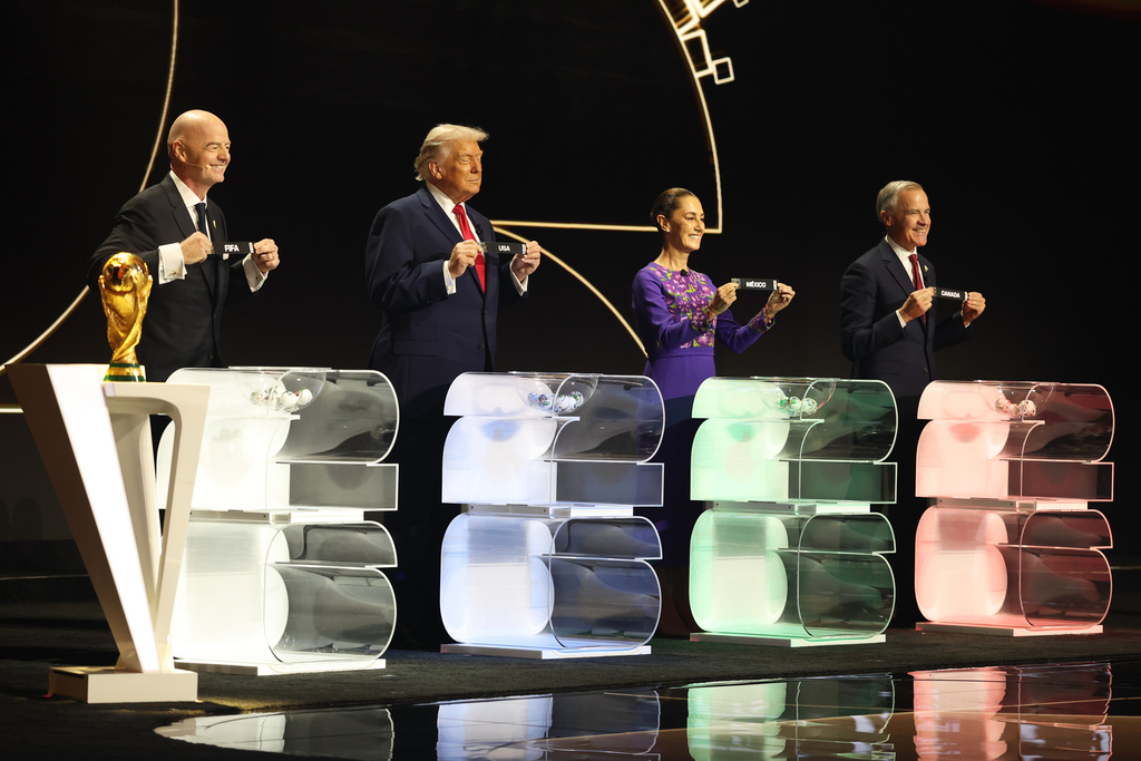 (left to right) FIFA President Gianni Infantino,President Donald Trump, Mexican President Claudia Sheinbaum and Canadian Prime Minister Mark Carney smile during the draw for the 2026 soccer World Cup at the Kennedy Center in Washington, Friday, Dec. 5, 2025. (Dan Mullan/Pool Photo via AP)