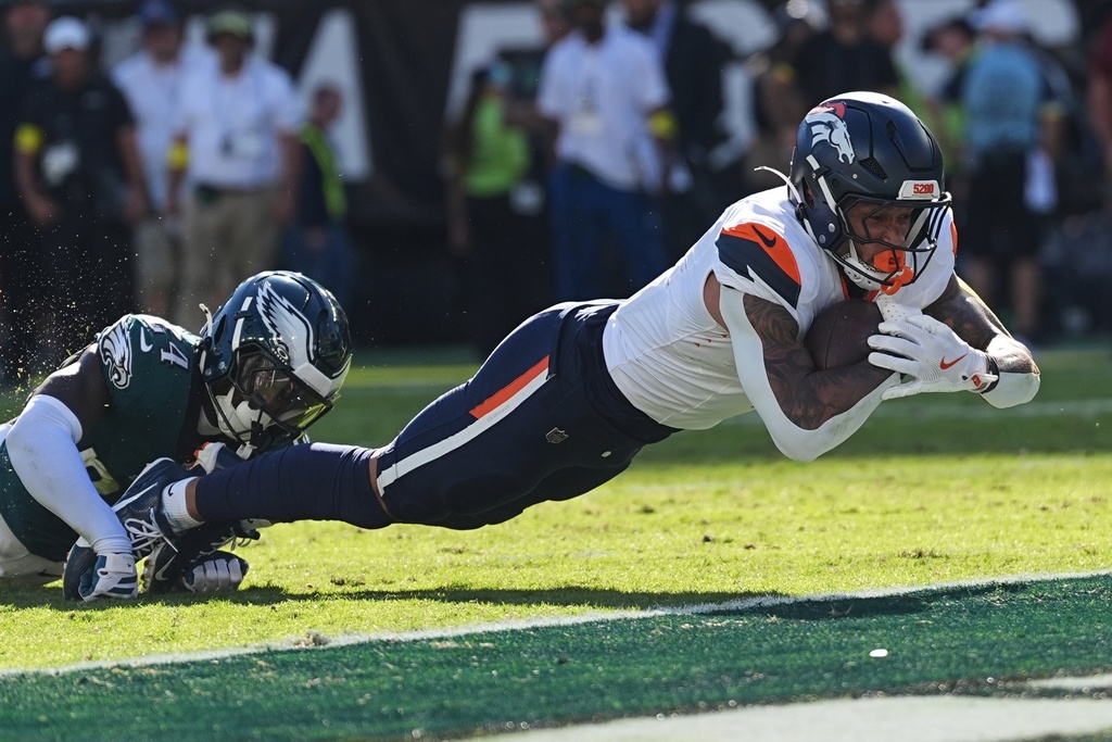 Denver Broncos tight end Evan Engram scores a touchdown in front of Philadelphia Eagles safety Andrew Mukuba (24) during the second half of an NFL football game Sunday, Oct. 5, 2025, in Philadelphia. (AP Photo/Matt Rourke)