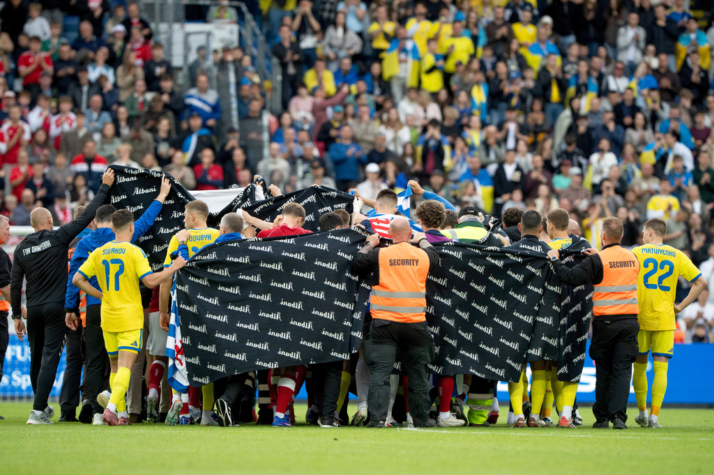 Denmark's and Ukraine's players accompany Christian Eriksen to a waiting ambulance during the international friendly soccer match between Denmark and Ukraine in Odense, Denmark, Sunday, June 7, 2026, after Eriksen has collapsed on the field again while playing for Denmark’s national team. (Bo Amstrup/Ritzau Scanpix via AP)