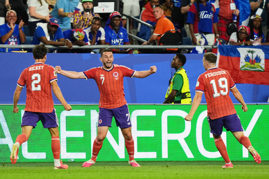 Scotland's John McGinn (7) celebrates with teammate's Aaron Hickey (2) and Lewis Ferguson (19) after scoring his teams first goal during the World Cup Group C soccer match between Haiti and Scotland in Foxborough, Mass., near Boston, Saturday, June 13, 2026. (AP Photo/Martin Meissner)
