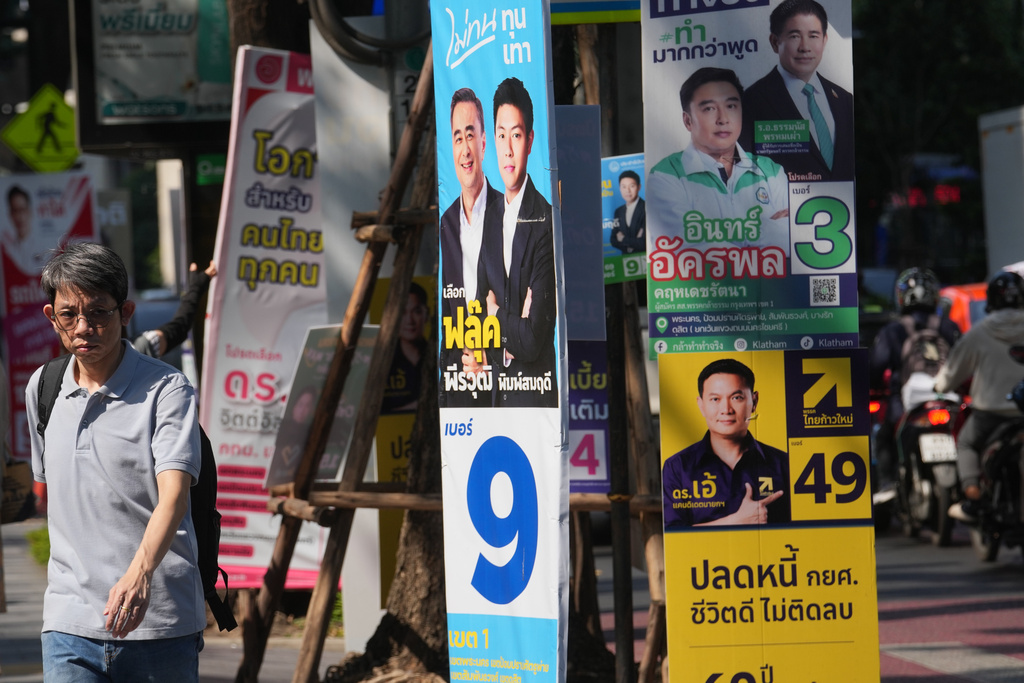 A man walks next to political parties' election campaign posters in Bangkok, Thailand, Wednesday, Feb. 4, 2026. (AP Photo/Sakchai Lalit)