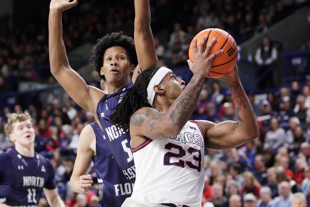 Gonzaga guard Adam Miller (23) drives to the basket while pressured byh North Florida guard Dante Oliver (5) during the first half of an NCAA college basketball game, Sunday, Dec. 7, 2025, in Spokane, Wash. (AP Photo/Young Kwak)
