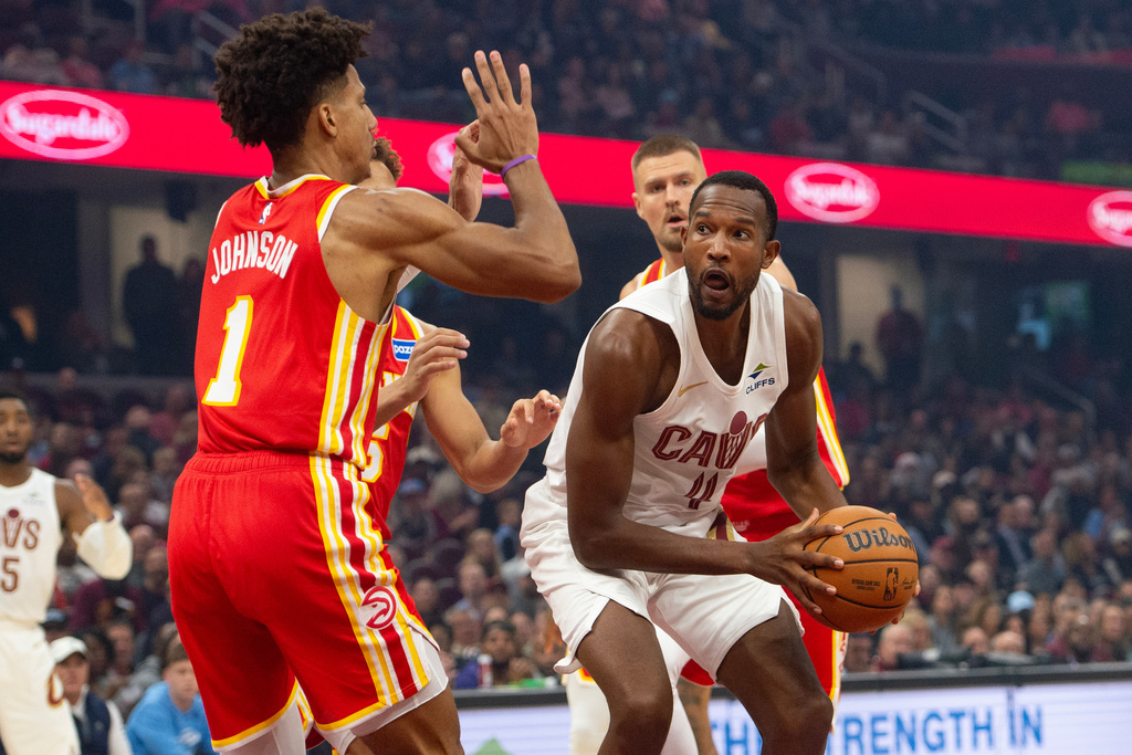 Atlanta Hawks' Jalen Johnson (1) defends as Cleveland Cavaliers' Evan Mobley (4) prepares to shoot during the first half of an NBA basketball game in Cleveland, Sunday, Nov. 2, 2025. (AP Photo/Phil Long)
