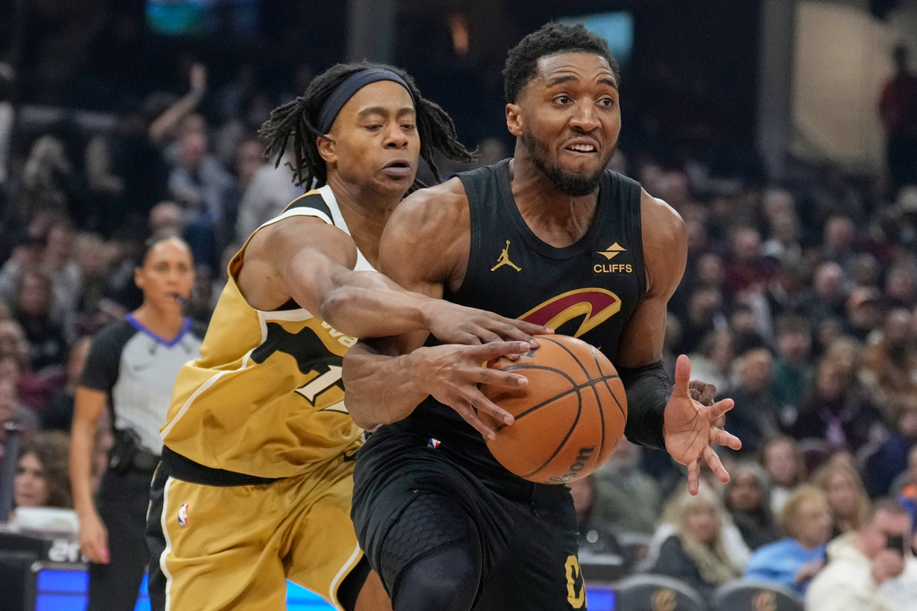 Washington Wizards' Skal Labissiere, left, knocks the ball away from Cleveland Cavaliers guard Donovan Mitchell, right, in the first half of an NBA basketball game in Cleveland, Wednesday, Feb. 11, 2026. (AP Photo/Sue Ogrocki)