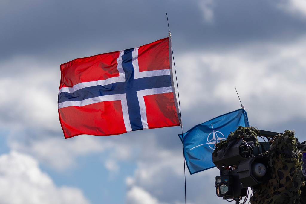 FILE - Norway's, left, and NATO's flags are seen during a military exercise 'Iron Wolf 2025-I' at the Gaiziunai Training Area, Lithuania, on May 16, 2025. (AP Photo/Mindaugas Kulbis, File)