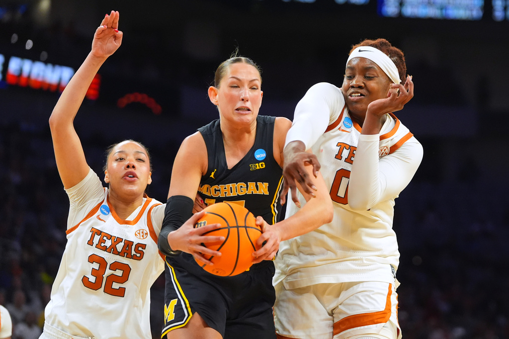 Michigan forward Ashley Sofilkanich (15) pulls down a rebound from Texas forward Teya Sidberry (32) and Texas center Kyla Oldacre (00) during the first half in the Elite Eight of the NCAA college basketball tournament, Monday, March 30, 2026, in Fort Worth, Texas. (AP Photo/LM Otero)