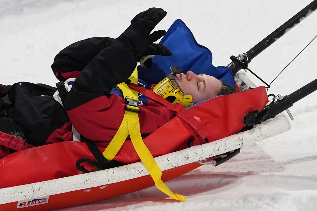 Canada's Cassie Sharpe blows kisses as medics stretcher her off after crashing during the women's freestyle skiing halfpipe qualifications at the 2026 Winter Olympics, in Livigno, Italy, Thursday, Feb. 19, 2026. (AP Photo/Gregory Bull)