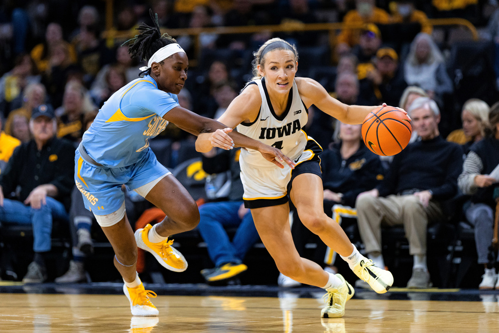 Iowa guard Kylie Feuerbach (4) dribbles as Southern guard Mykayla Cunningham (8) defends during an NCAA college basketball game in Iowa City, Iowa, Monday, Nov. 3, 2025. (Nick Rohlman/The Gazette via AP)