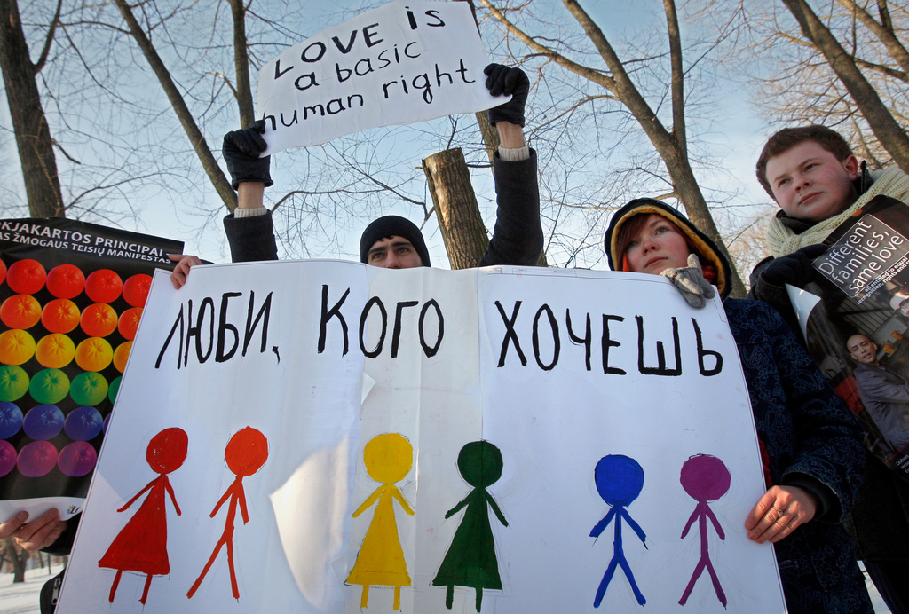 FILE - Activists hold placards during a picket, authorised by the authorities, against homophobia in front of the Department of Justice in Minsk, Belarus, Monday, Feb. 14, 2010. The sign on placard reads "Love who you want". (AP Photo, File)