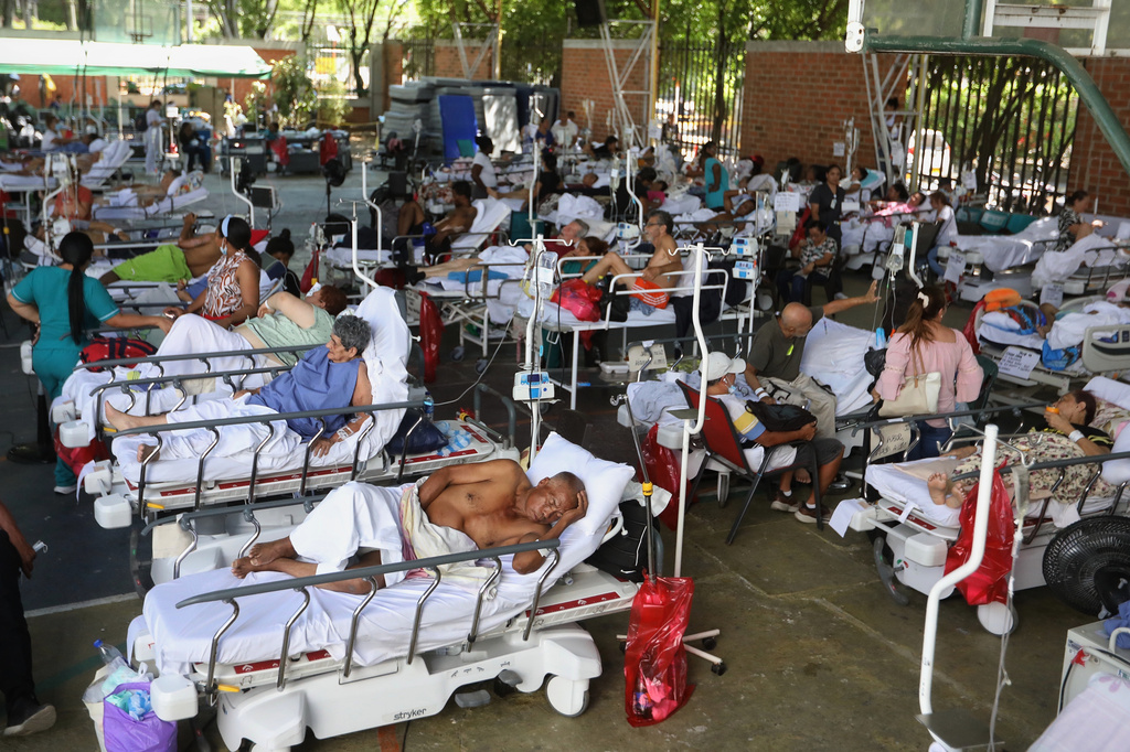 Patients from a clinic evacuated due to earthquake damage lie in beds at a temporary facility set up in a gymnasium at a nearby school in Cali, Colombia, Tuesday, Aug. 11, 2026. (AP Photo/Santiago Saldarriaga)