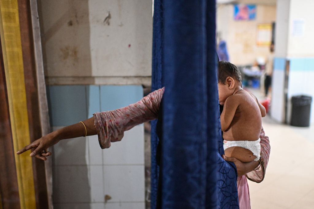 A woman brings her child for treatment of measles outbreak in a hospital in Dhaka, Bangladesh, Tuesday, Sept. 8, 2026. (AP Photo/Mahmud Hossain Opu)