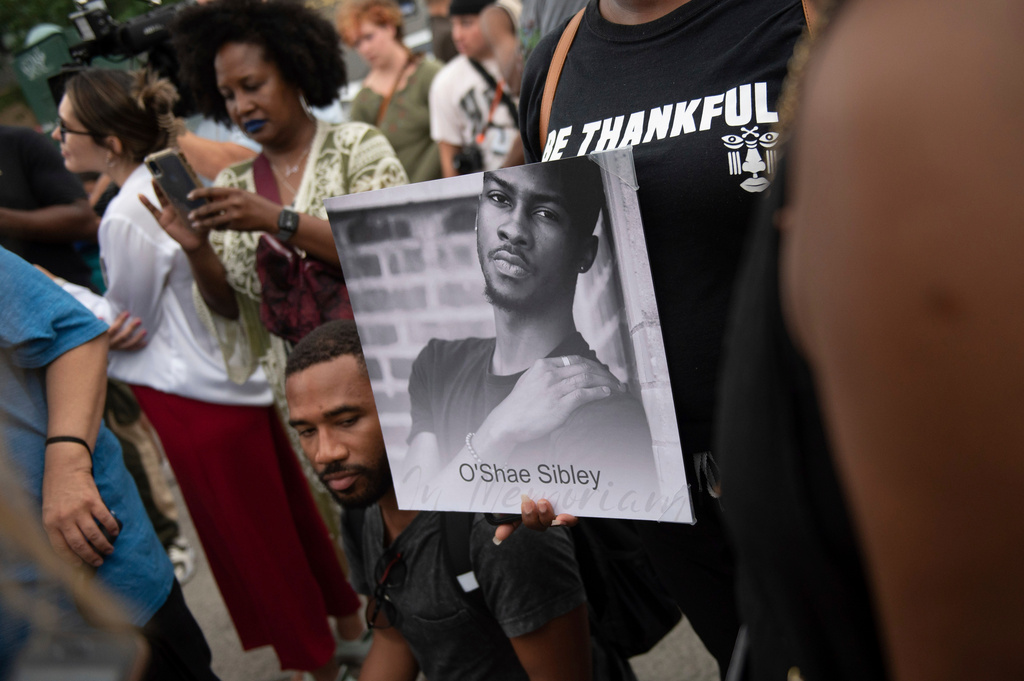 FILE - A person holds up a photo of O'Shae Sibley during a vigil at a gas station, Aug. 4, 2023, in the Brooklyn borough of New York. (AP Photo/Tracie Van Auken, File)