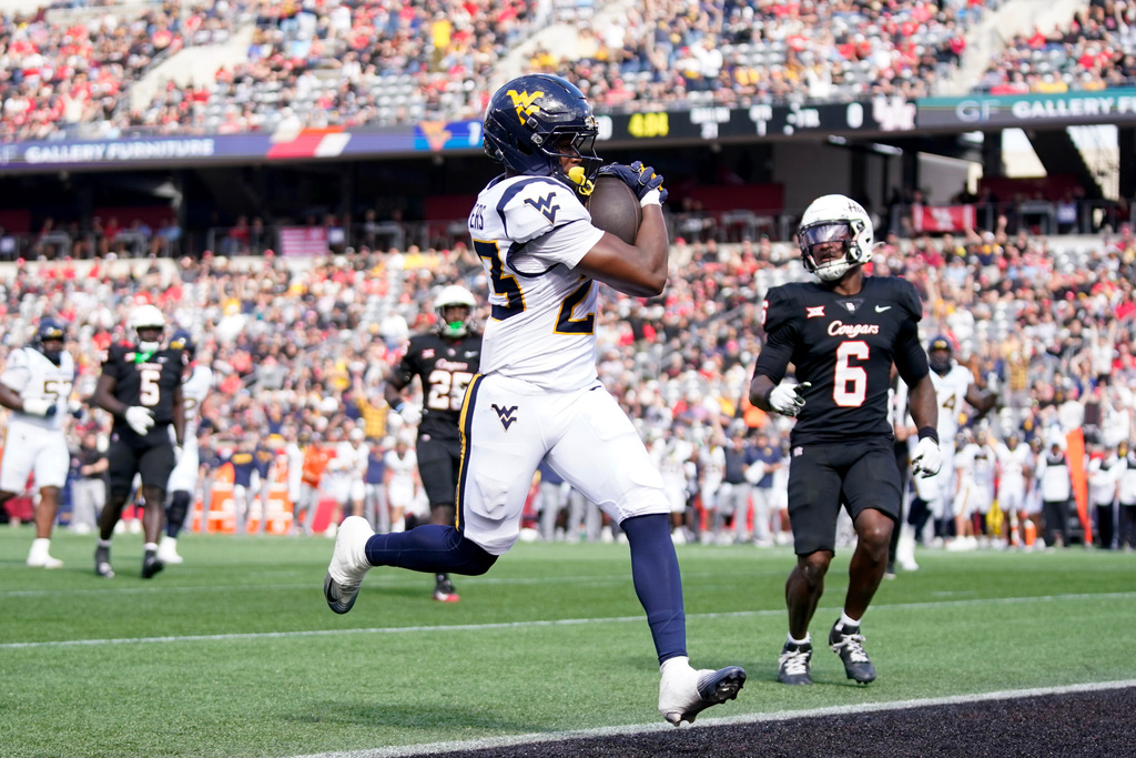 West Virginia running back Cyncir Bowers, center, runs into the end zone for a touchdown against Houston during the first half of an NCAA college football game Saturday, Nov. 1, 2025, in Houston. (AP Photo/Eric Christian Smith)