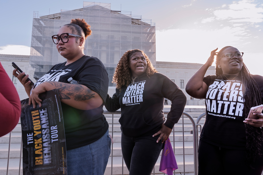 Voting rights activists gather outside the Supreme Court in Washington, early Wednesday, Oct. 15, 2025, as the justices prepare to take up a major Republican-led challenge to the Voting Rights Act, the centerpiece legislation of the Civil Rights Movement. (AP Photo/J. Scott Applewhite)