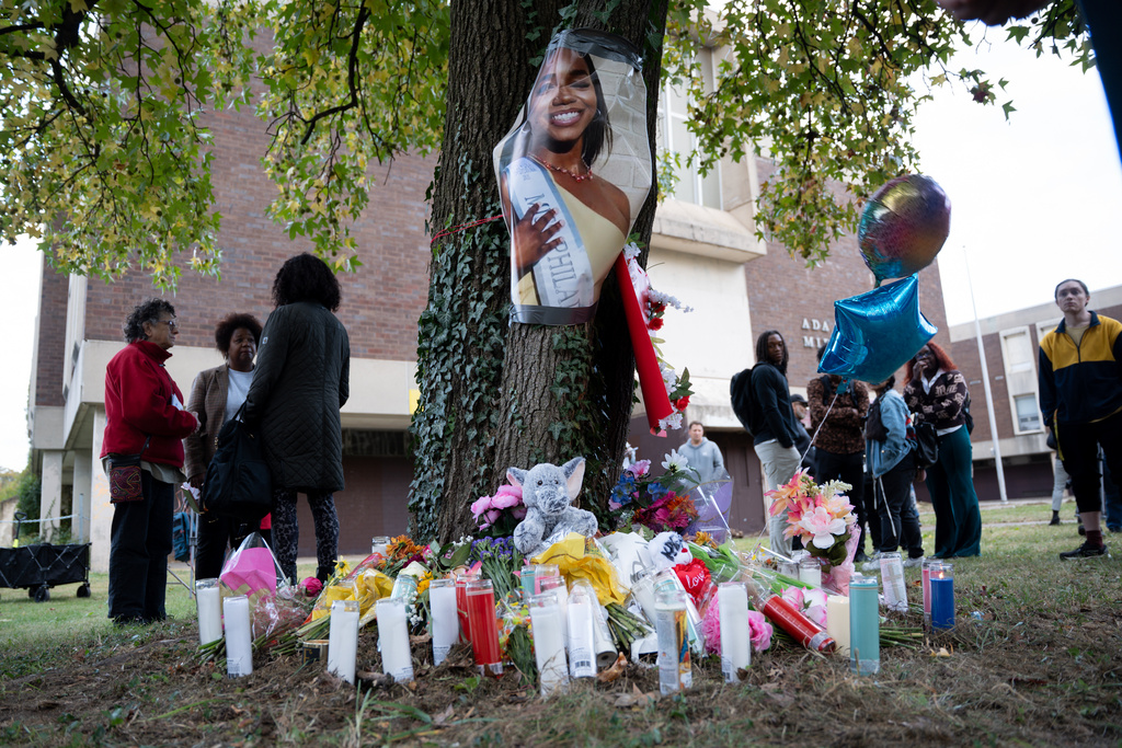 People gather at a memorial for Kada Scott, near the abandoned Ada H. H. Lewis Middle School Monday, Oct. 20, 2025, in Philadelphia, where she was found earlier. (AP Photo/Mingson Lau)