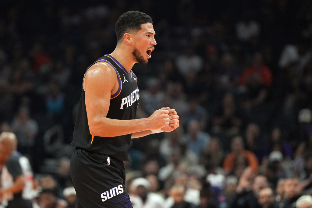 Phoenix Suns guard Devin Booker reacts after scoring against the Utah Jazz during the first half of an NBA basketball game, Friday, Oct. 31, 2025, in Phoenix. (AP Photo/Rick Scuteri)