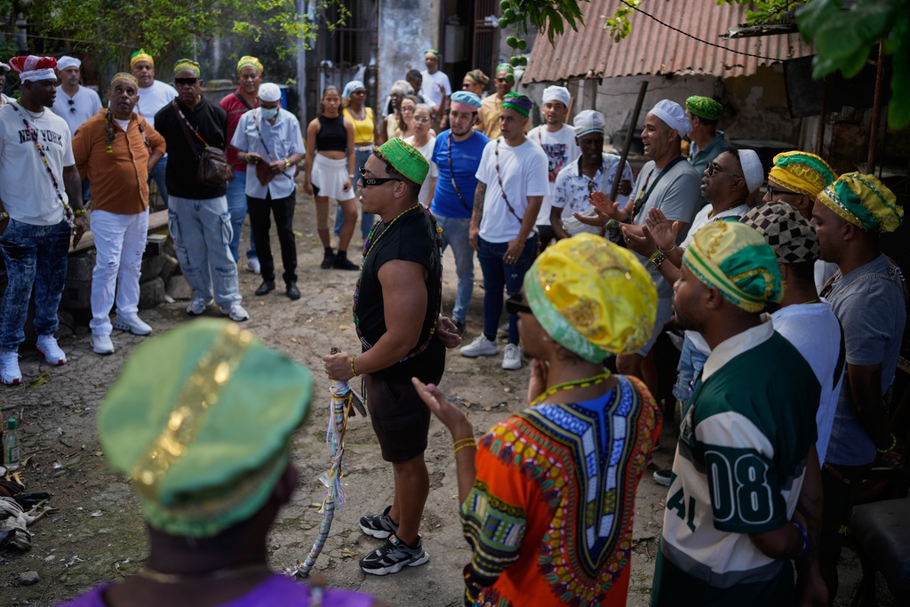 Santeria priests, also known as Babalawos, perform a cleansing ritual with roosters during a ceremony calling for peace and health in Havana, Sunday, Jan. 25, 2026. (AP Photo/Ramon Espinosa)