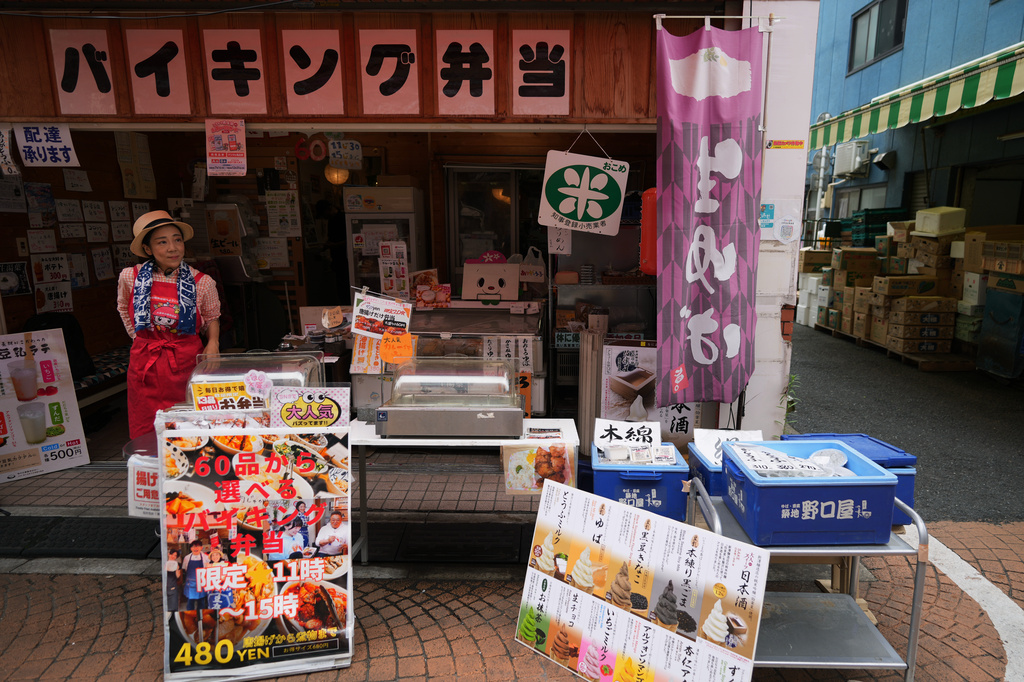 Akiko Sugaya waits for customers at her takeout lunch shop, which turns into a dine-in restaurant in the evening, in Tokyo, Saturday, July 4, 2026. (AP Photo/Hiro Komae)