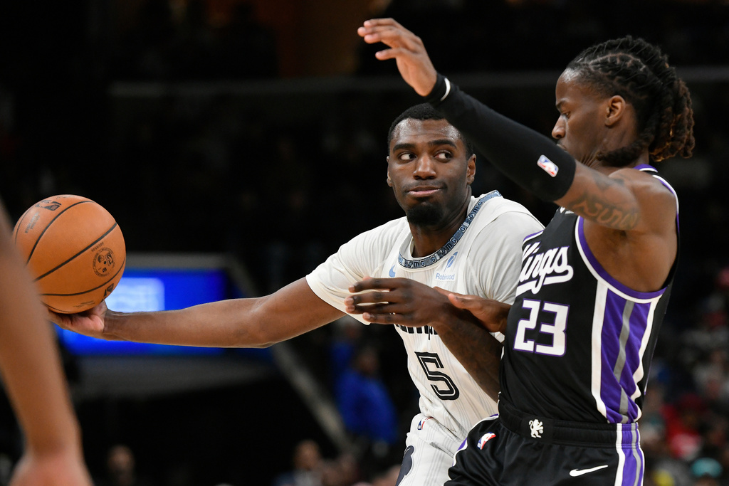 Memphis Grizzlies guard Vince Williams Jr. (5) handles the ball against Sacramento Kings guard Keon Ellis (23) in the first half of an NBA basketball game Thursday, Nov. 20, 2025, in Memphis, Tenn. (AP Photo/Brandon Dill)