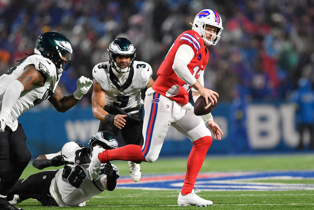 Buffalo Bills' Josh Allen (17) tries to ge away from Philadelphia Eagles' Jalyx Hunt (58), Jalen Carter (98) and Nolan Smith (3) during the second half of an NFL football game, Sunday, Dec. 28, 2025, in Buffalo, N.Y. (AP Photo/Adrian Kraus)