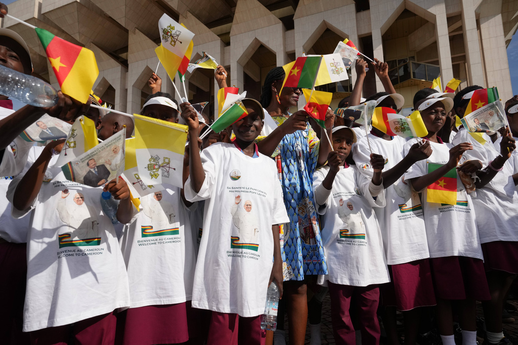 Children wave Cameroon and Vatican flags to greet Pope Leo XIV upon his arrival in Yaounde, Cameroon, Wednesday, April 15, 2026, on the third day of an 11-day apostolic journey to Africa. (AP Photo/Andrew Medichini)