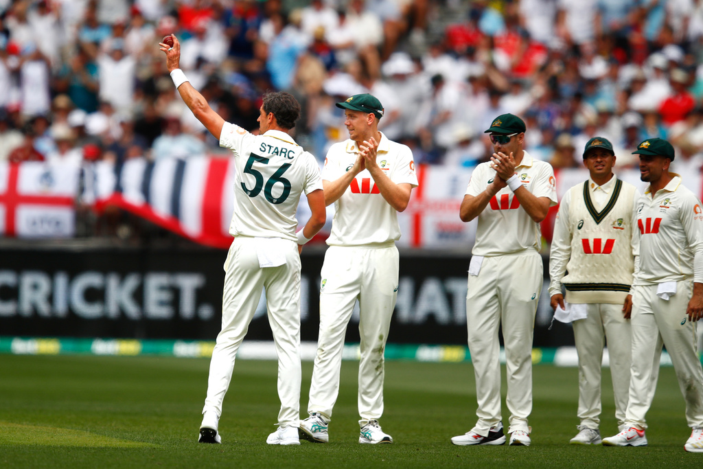 Australia's Mitchell Starc, left, lifts the ball to acknowledge his tenth wicket in the first Ashes cricket test match between Australia and England in Perth, Saturday, Nov. 22, 2025.(AP Photo/Gary Day)