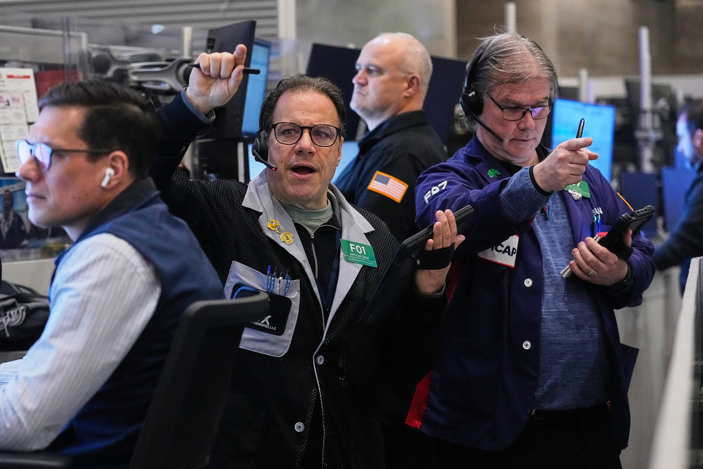 Options traders Anthony Spina, second left, and Brian Garvey, right, work on the floor of the New York Stock Exchange, Wednesday, Jan. 21, 2026. (AP Photo/Richard Drew)