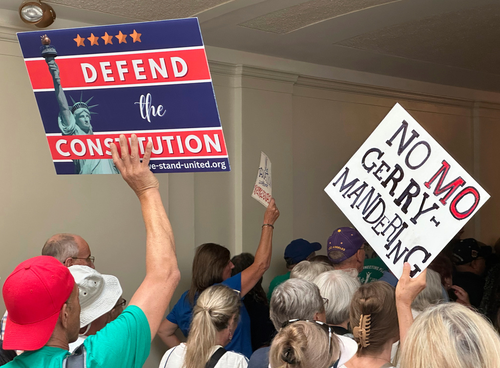 Opponents of a Republican plan to redraw Missouri's U.S. House districts march through a hallway outside the state Senate chamber in Jefferson City, Mo., Wednesday, Sept. 10, 2025. (AP Photo/David A. Lieb)