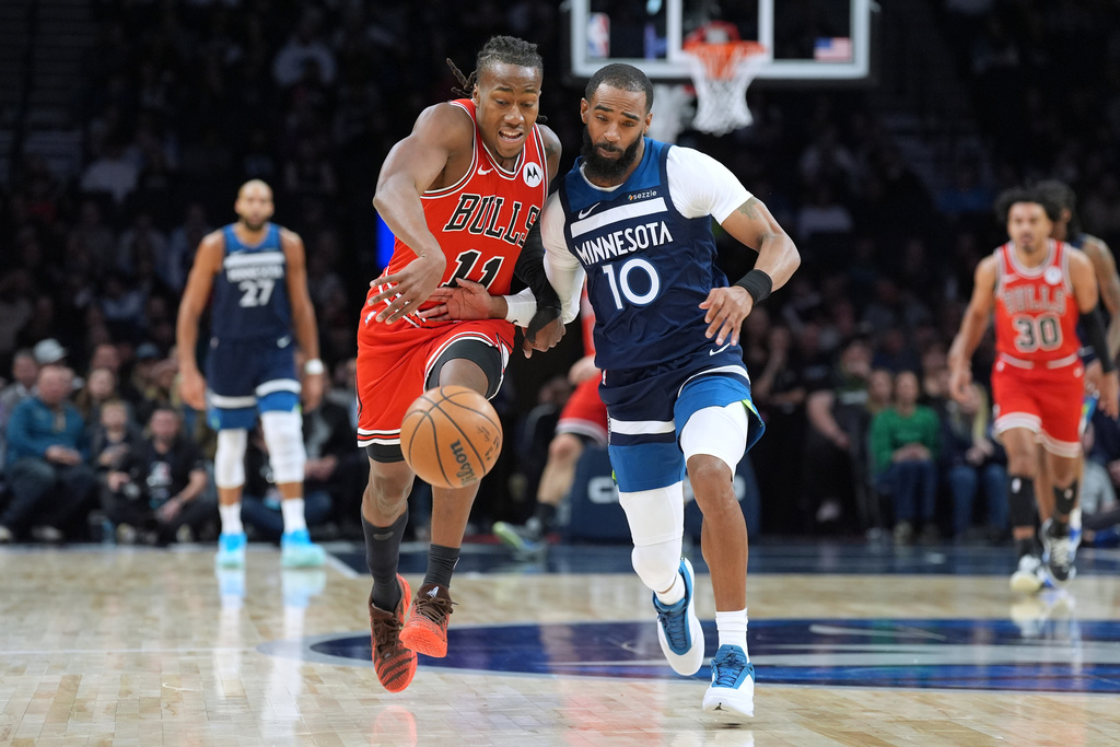 Chicago Bulls guard Ayo Dosunmu (11) and Minnesota Timberwolves guard Mike Conley (10) try to gain possession of the ball during the first half of an NBA basketball game, Thursday, Jan. 22, 2026, in Minneapolis. (AP Photo/Abbie Parr)