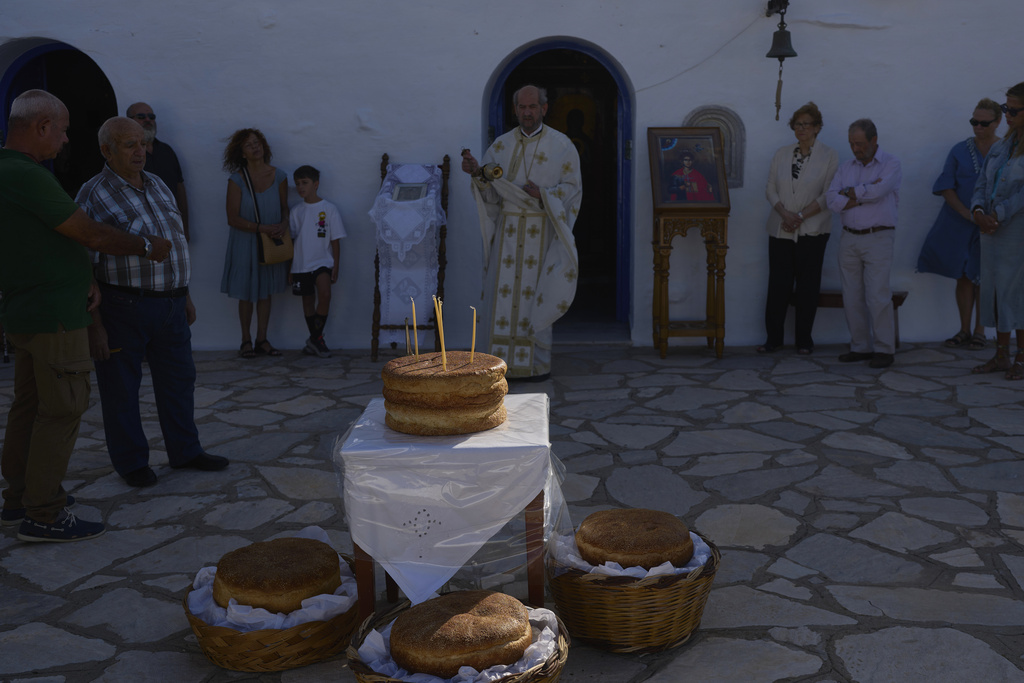 Greek Orthodox priest Antonios Stathopoulos swings a censer during a liturgy at the family-owned Agios Sostis chapel on the island of Tinos, Greece, Monday, Sept. 8, 2025. (AP Photo/Petros Giannakouris)