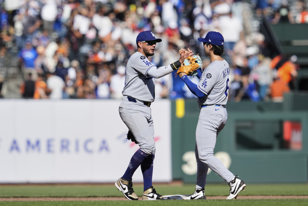 Los Angeles Dodgers shortstop Miguel Rojas, left, and second baseman Hyeseong Kim celebrate after the team's victory over the San Francisco Giants in a baseball game Sunday, Sept. 14, 2025, in San Francisco. (AP Photo/Godofredo A. Vásquez)