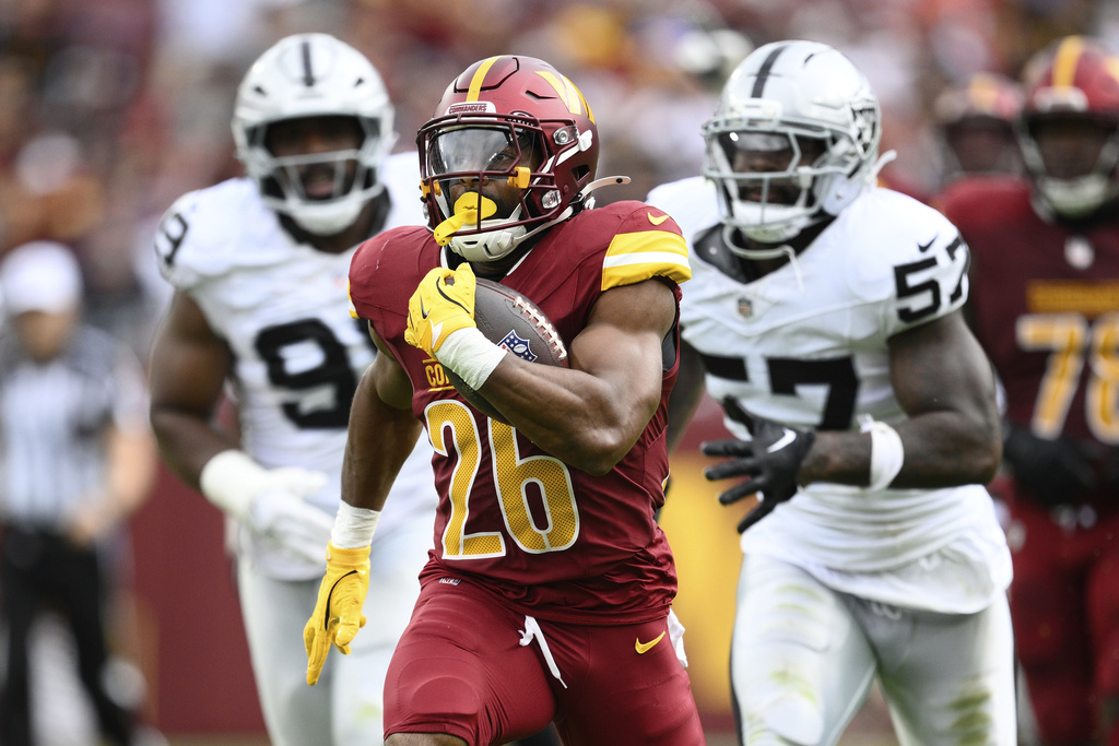 Washington Commanders running back Jeremy McNichols (26) runs in a touchdown during the first half of NFL football game against the Las Vegas Raiders, Sunday, Sept. 21, 2025, in Landover, Md. (AP Photo/Nick Wass)