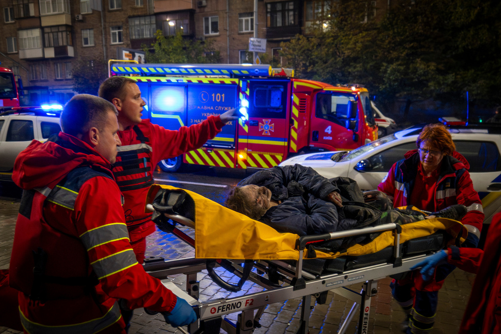 Paramedics evacuate an injured woman after a Russian strike on a residential building in Kyiv, Ukraine, Friday, Oct. 10, 2025. (AP Photo/Dan Bashakov)