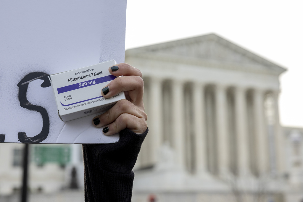 FILE - An abortion-rights activist holds a box of mifepristone pills as demonstrators from both anti-abortion and abortion-rights groups rally outside the Supreme Court in Washington, on March 26, 2024. (AP Photo/Amanda Andrade-Rhoades, File)