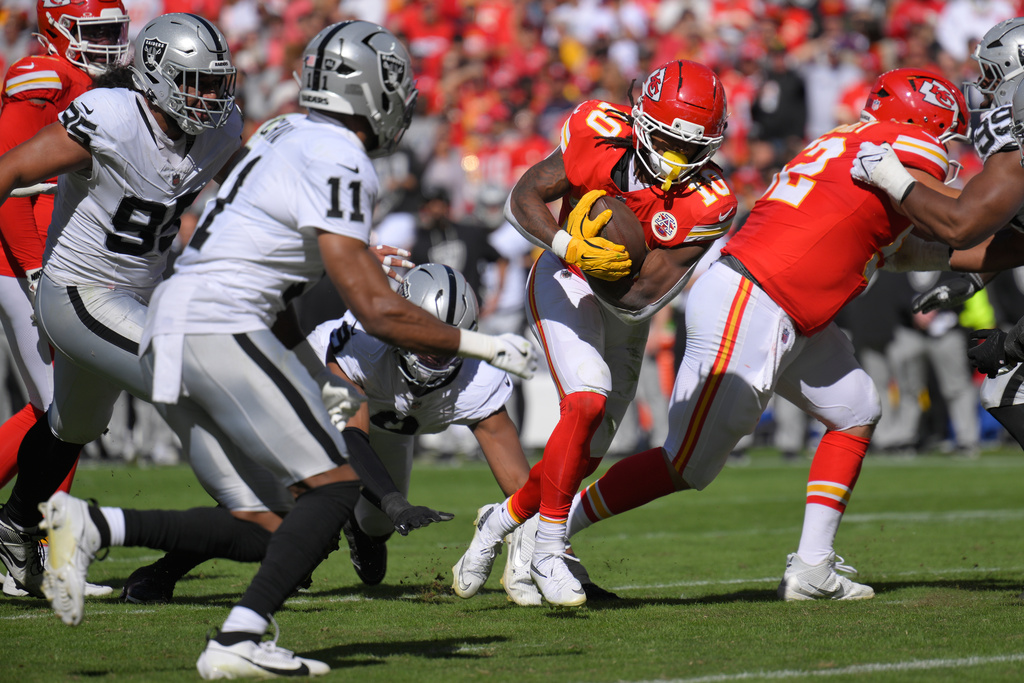 Kansas City Chiefs running back Isiah Pacheco (10) scores by Las Vegas Raiders safety Jeremy Chinn (11) during the second half of an NFL football game Sunday, Oct. 19, 2025, in Kansas City, Mo. (AP Photo/Reed Hoffmann)