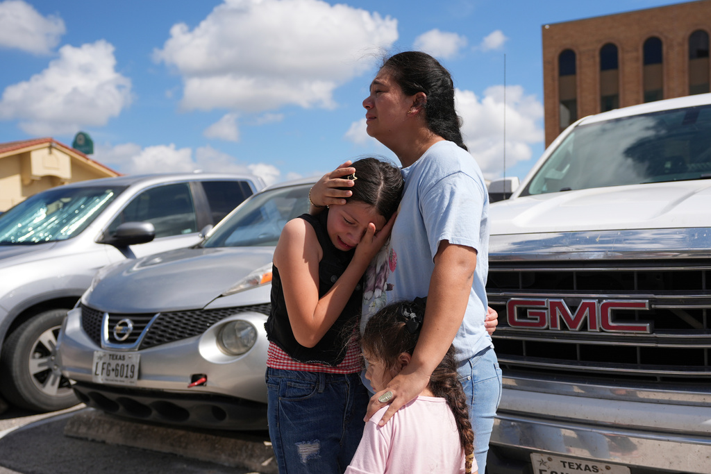 Narel Lopez comforts her daughters after her husband and a son were detained and taken away in a bus following an appearance at immigration court, June 25, 2025, in San Antonio, Texas. (AP Photo/Eric Gay, File)