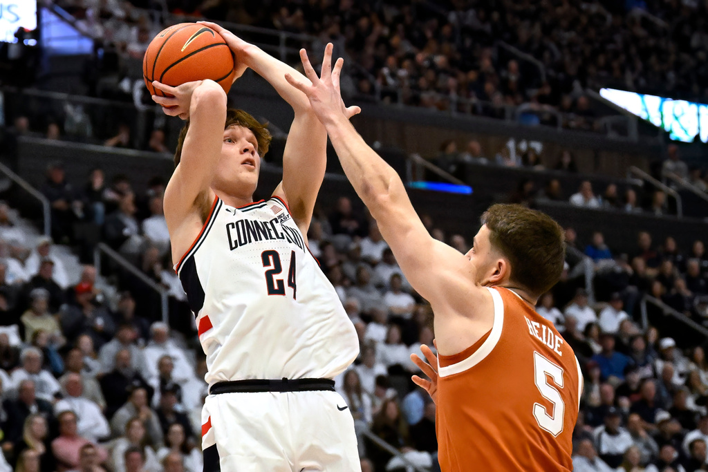 UConn guard Braylon Mullins (24) shoots as Texas forward Camden Heide (5) defends in the first half of an NCAA college basketball game, Friday, Dec. 12, 2025, in Hartford, Conn. (AP Photo/Jessica Hill)