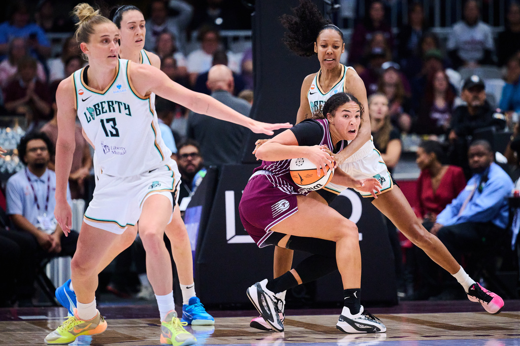 Toronto Tempo's Kiki Rice, front right, looks to pass the ball as New York Liberty's Rebekah Gardner, back right, defends during the first half of a WNBA basketball game in Toronto, Sunday, Sept. 20, 2026. (Sammy Kogan/The Canadian Press via AP)