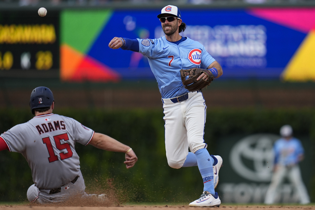 Chicago Cubs shortstop Dansby Swanson (7), right, forces out Washington Nationals' Riley Adams (15) a second base and throws to first for a double play during the fifth inning of a baseball game Friday, Sept. 5, 2025, in Chicago. (AP Photo/Erin Hooley)