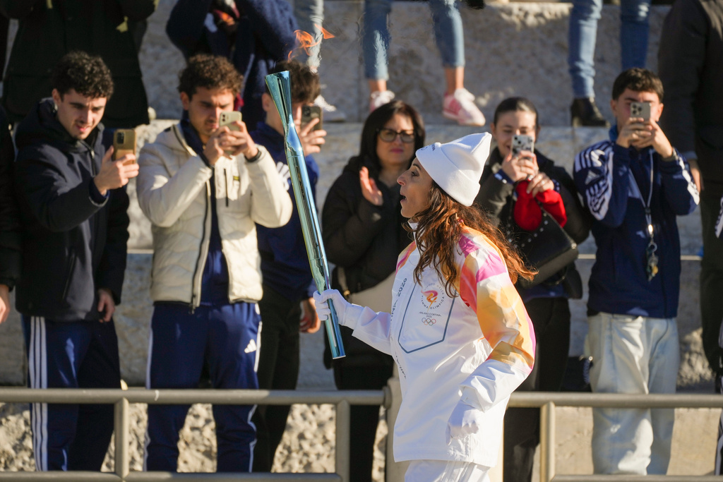 Italian former foil fencer and Olympic and world champion Elisa Di Francisca carries the 2026 Milan Cortina Winter Olympics torch in Rome as it begins its journey through Italy, Saturday, Dec. 6, 2025, a journey that will conclude in Milan in February 2026. (AP Photo/Andrew Medichini)