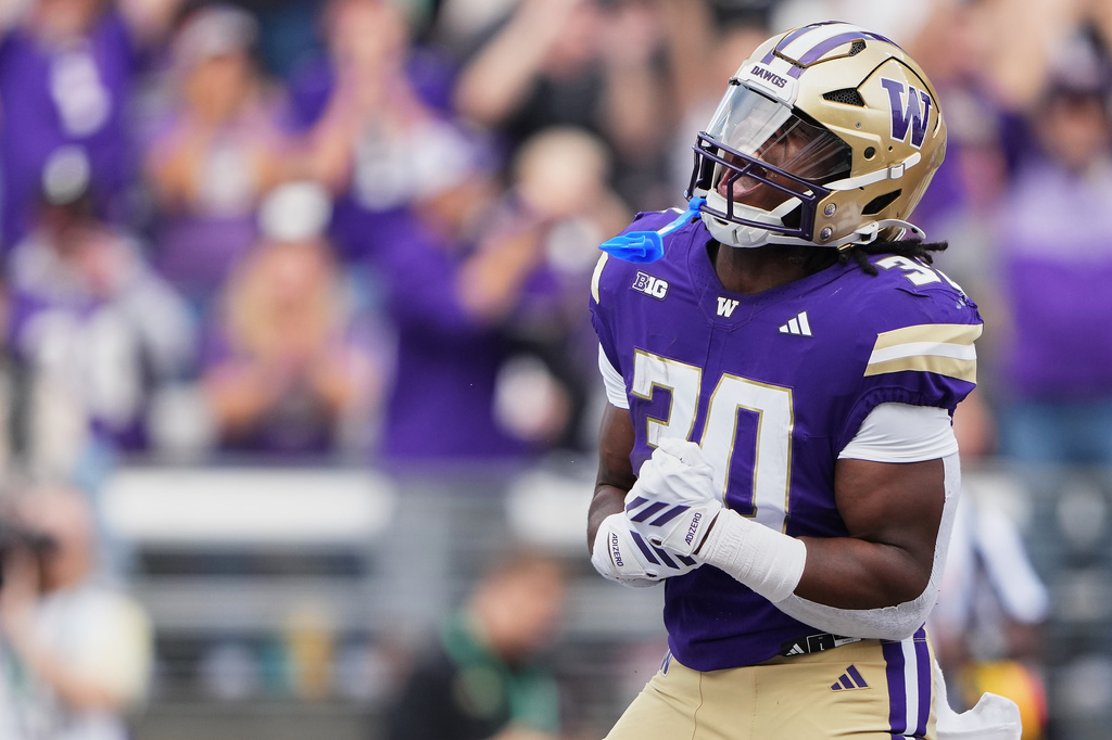 Washington running back Ansu Sanoe reacts after scoring a touchdown against Utah State during the first half of an NCAA college football game Saturday, Sept. 12, 2026, in Seattle. (AP Photo/Lindsey Wasson)