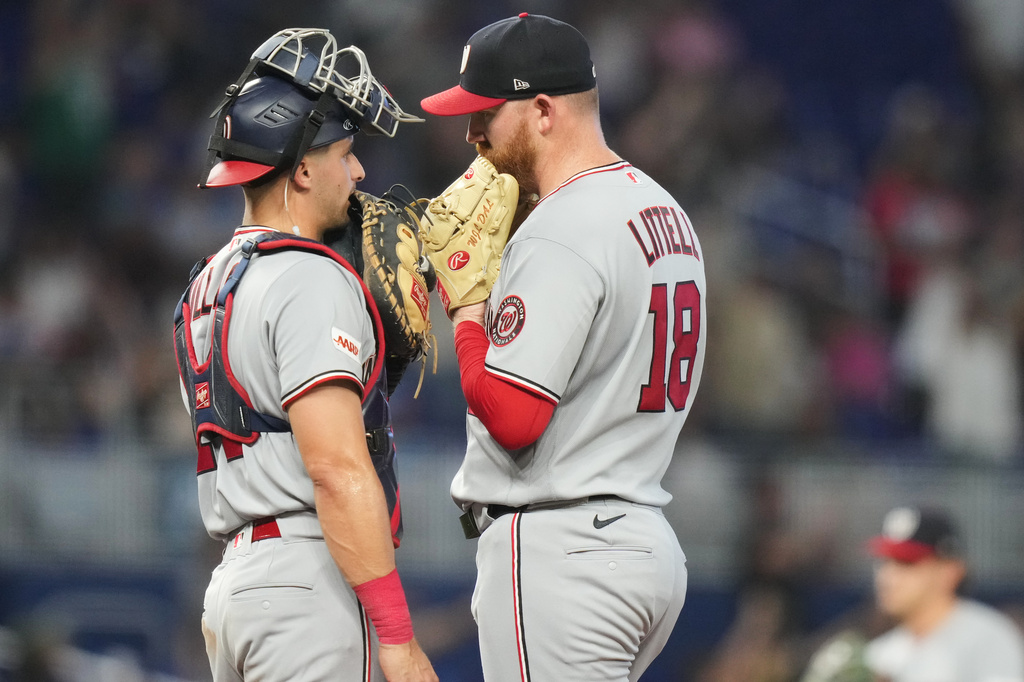 Washington Nationals pitcher Zack Littell (18) talks with catcher Drew Millas, left, during the fourth inning of a baseball game against the Miami Marlins, Saturday, May 9, 2026, in Miami. (AP Photo/Lynne Sladky)