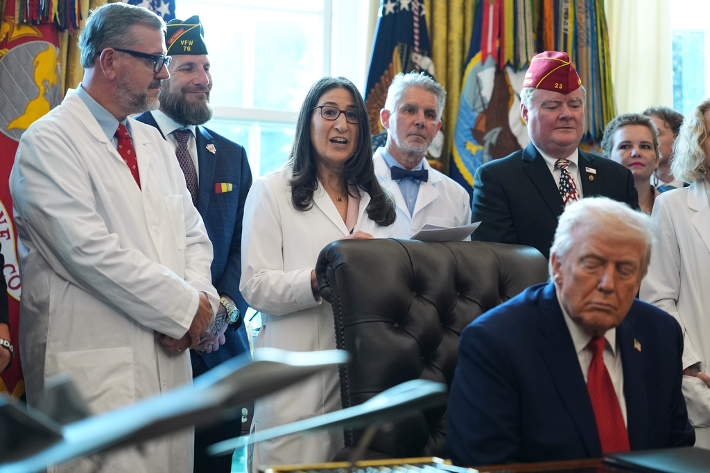 President Donald Trump listens as Dr. Ilana Braun, chief of Dana-Faber cancer Institute's Adult Psychosocial Oncology Service, speaks after the president signed an executive order reclassifying marijuana as a less dangerous drug in the Oval Office of the White House, Thursday, Dec. 18, 2025, in Washington. (AP Photo/Evan Vucci)