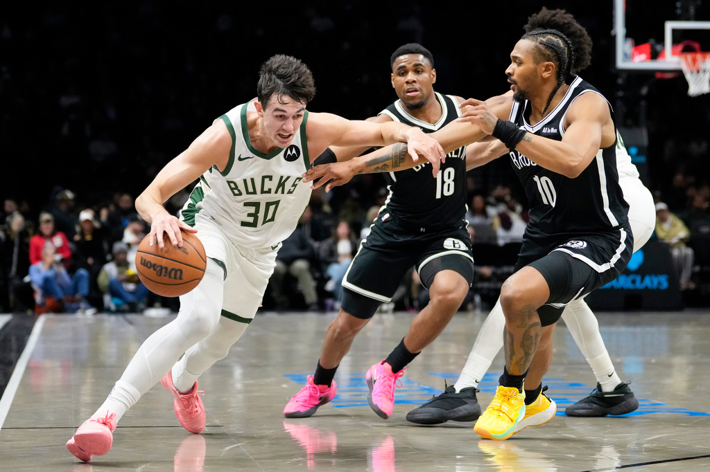 Milwaukee Bucks guard Cormac Ryan (30) drives past Brooklyn Nets guard Tyson Etienne (10) and Brooklyn Nets guard Malachi Smith (18) during the first half of an NBA basketball game, Tuesday, April 7, 2026, in New York. (AP Photo/Yuki Iwamura)