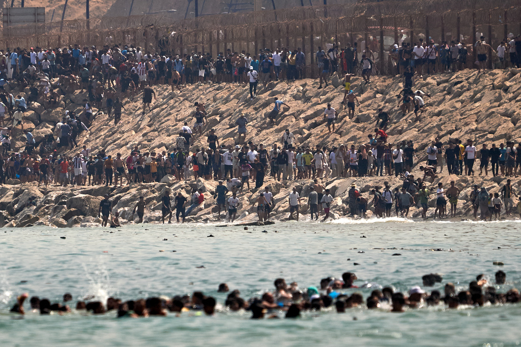 Migrants cross from Morocco into the Spanish enclave of Ceuta, Thursday, July 30, 2026. (AP Photo/Antonio Sempere)