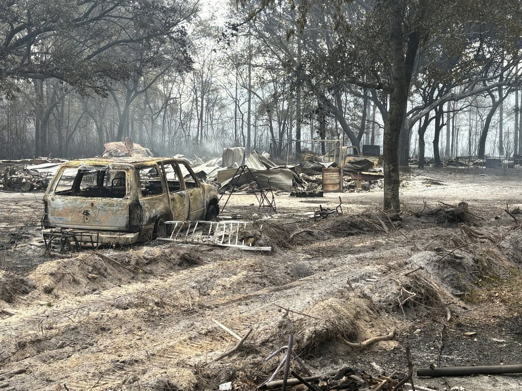 This photo provided by the Georgia Department of Natural Resources shows burned vehicles and trees from the Pineland Road Fire in southeast Georgia on Wednesday, April 22, 2026. (Georgia Department of Natural Resources via AP)