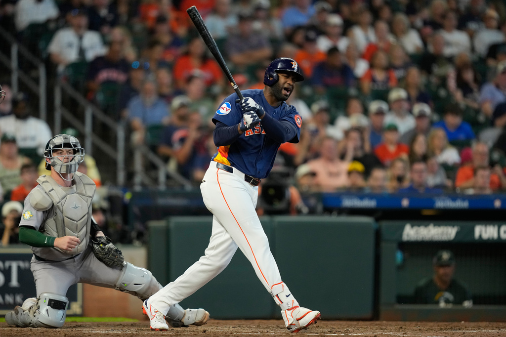 Houston Astros' Yordan Alvarez, right, reacts after fouling a pitch off his foot in front of Athletics catcher Brian Serven during the fourth inning of a baseball game Sunday, Aug. 23, 2026, in Houston. (AP Photo/David J. Phillip)
